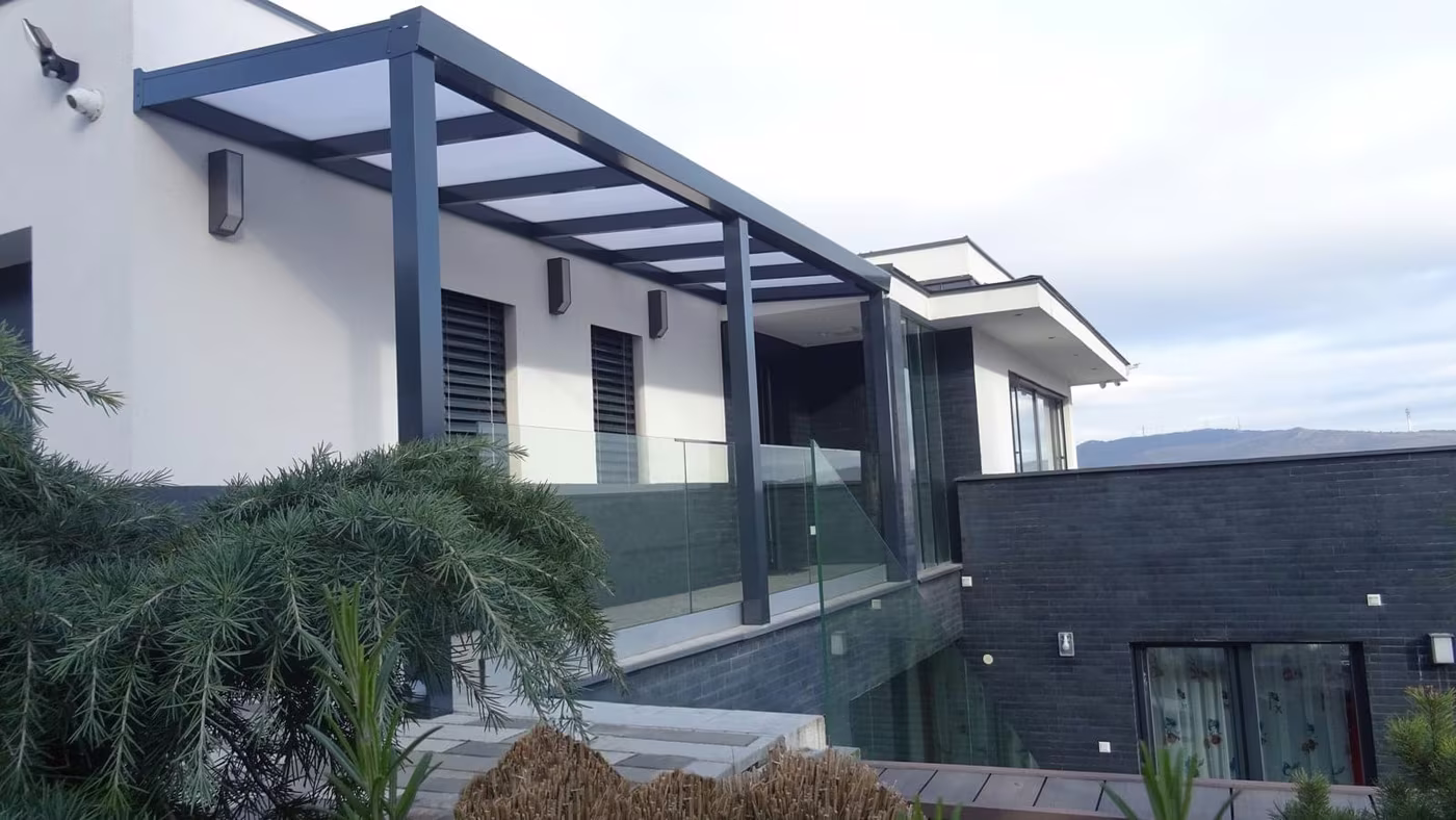 Antracit Economic Class alumínium pergola modern szürke ház mellett üvegkorláttal