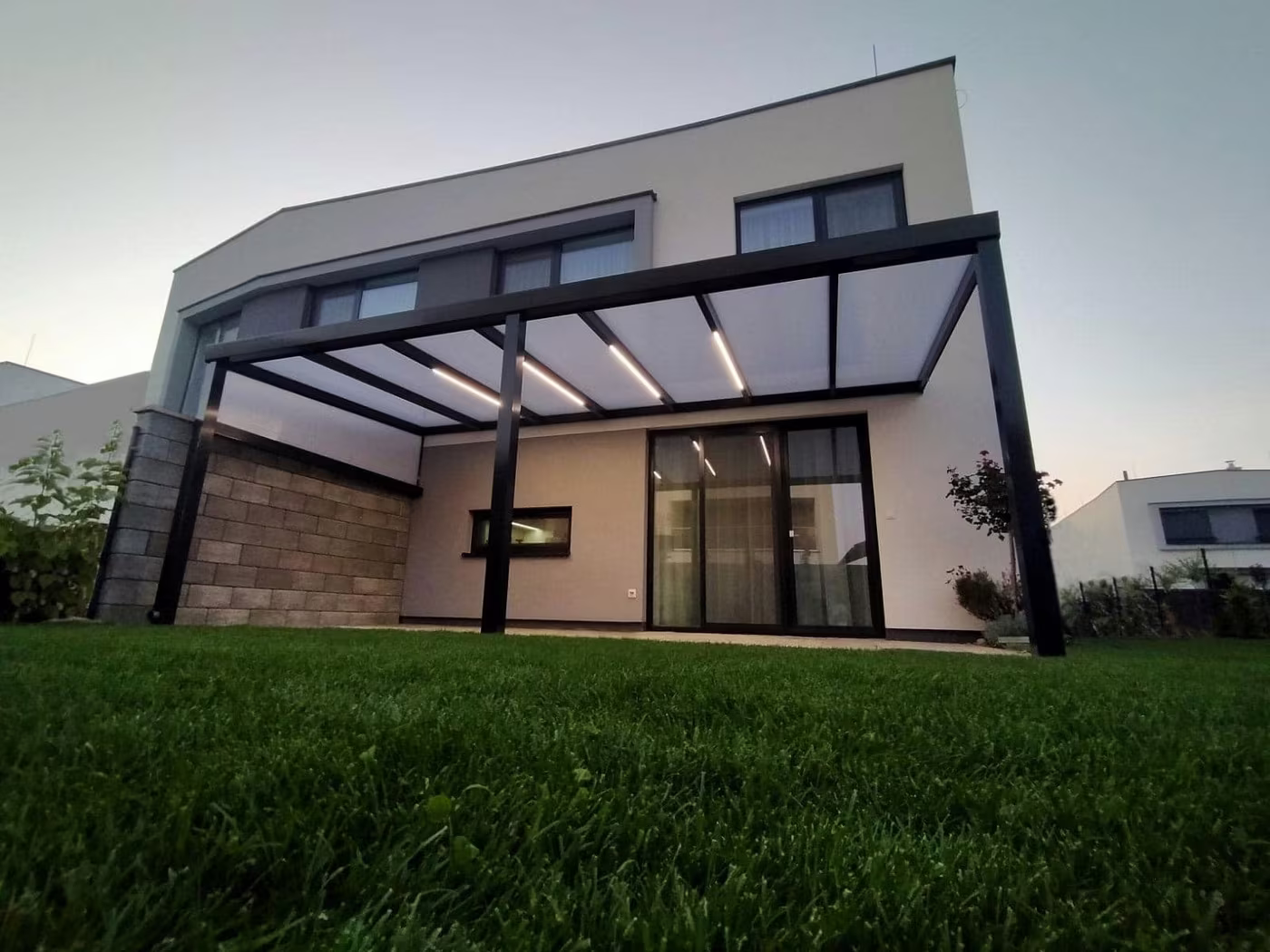 Antracit Economic Class alumínium pergola modern ház mellett alkonyatkor