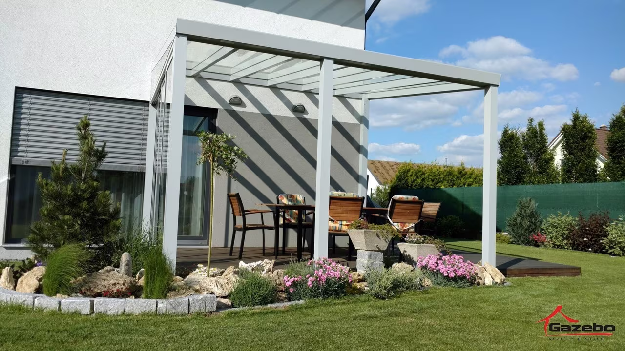 Fehér Top Class alumínium pergola terasz fölött étkezőgarnitúrával és rendezett kerttel